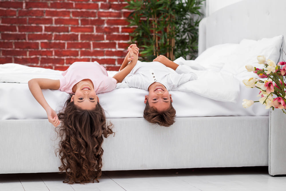 enfants sur un lit souriants